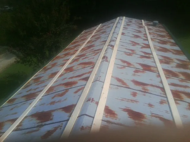 Rusted metal roof panels with new wood purlins before replacement — Storm Damage Roof Repair in Nelsonia by Roofing Brothers