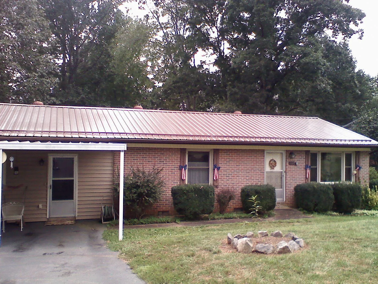 Bronze metal roof and carport on a brick ranch home — Roof Repair work by our crew in Nelsonia